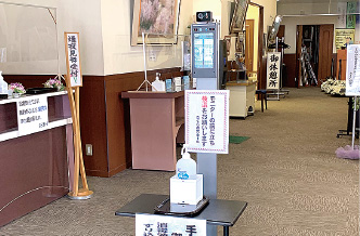 受付前の手指消毒と自動体温計測器の設置